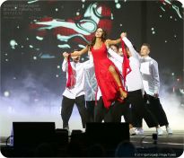 Певица Зара в красном платье на руках у мужчин - фото